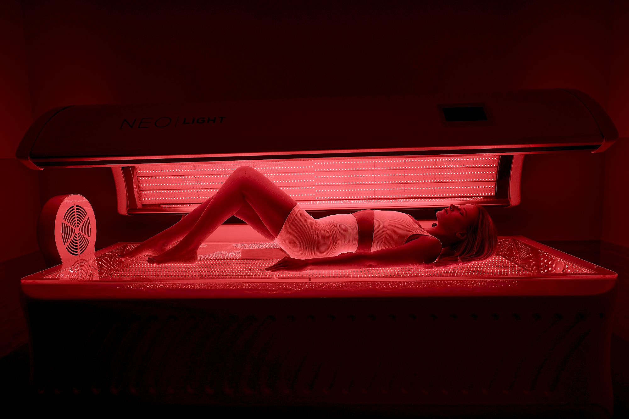 Client relaxing under the Neobed red light therapy bed